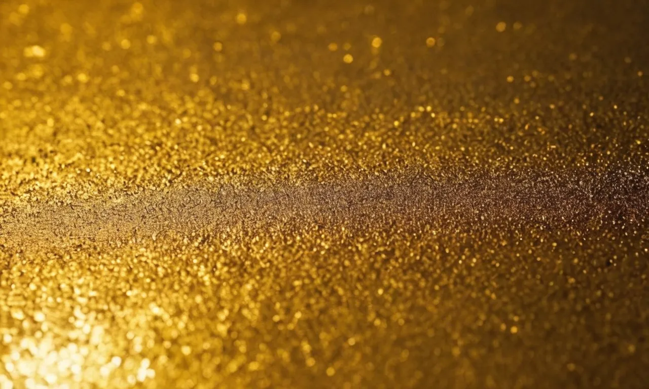 A close-up shot of a metal object covered in a lustrous coat of gold spray paint, capturing its shimmering brilliance and smooth texture.
