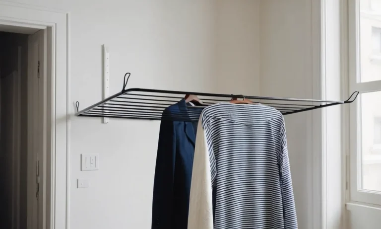 A close-up of a compact clothes drying rack hanging against a white wall in a small apartment, showcasing its efficient design for drying clothes in limited spaces.