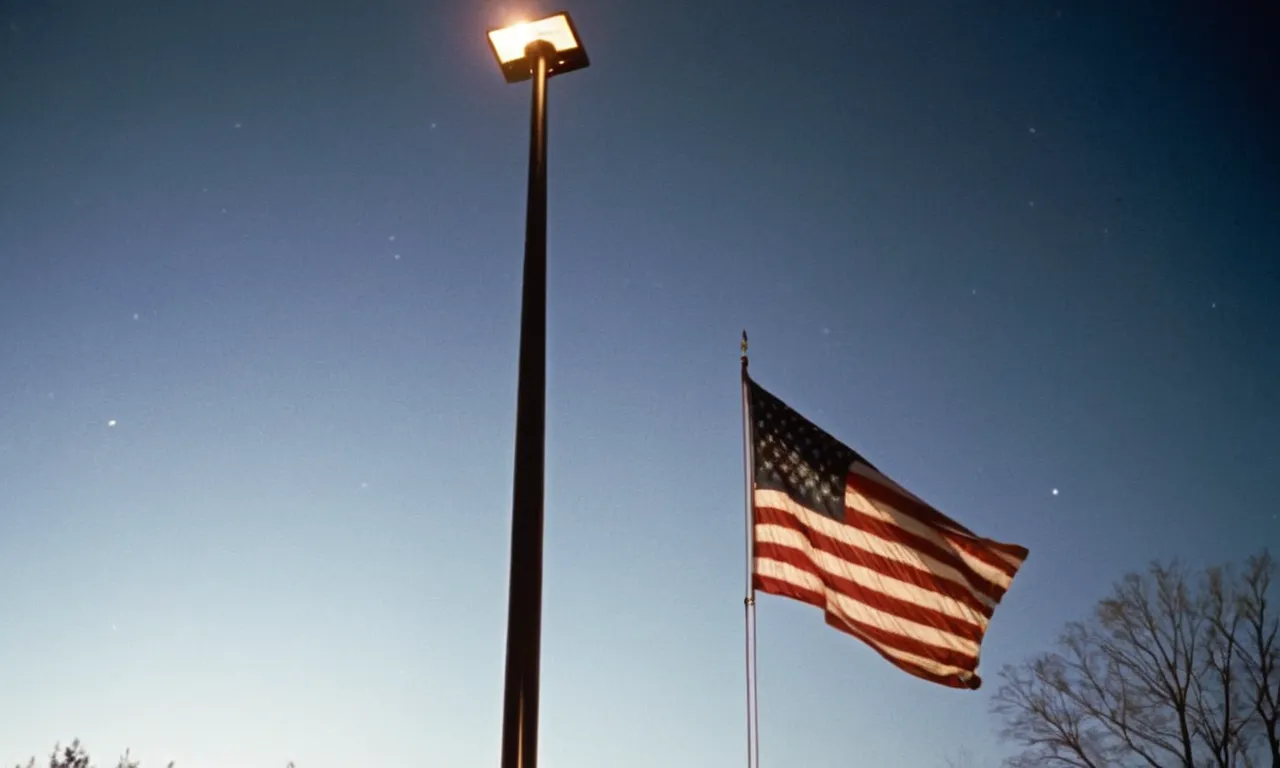 A captivating image capturing the illuminated American flag atop a flagpole at night, bathed in the warm glow of the best solar lights, symbolizing patriotism and sustainability.
