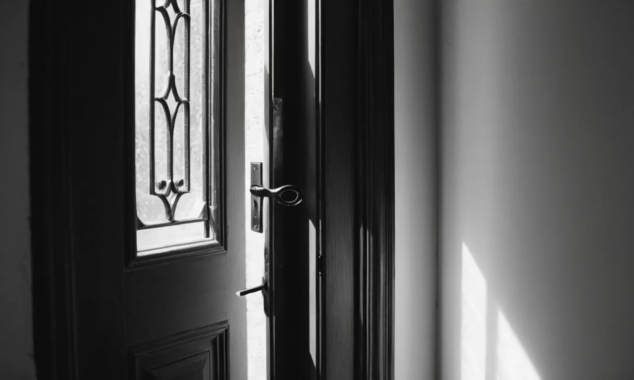 A black and white photo captures a hand reaching out to turn the handle of a closed door, while a vibrant, sunlit pathway emerges through a slightly ajar door nearby.