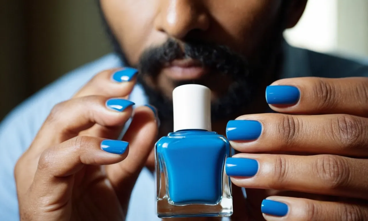A close-up photograph capturing a man's hands elegantly showcasing perfectly manicured blue nails, sparking curiosity and inviting contemplation about the motivation behind this unconventional choice.